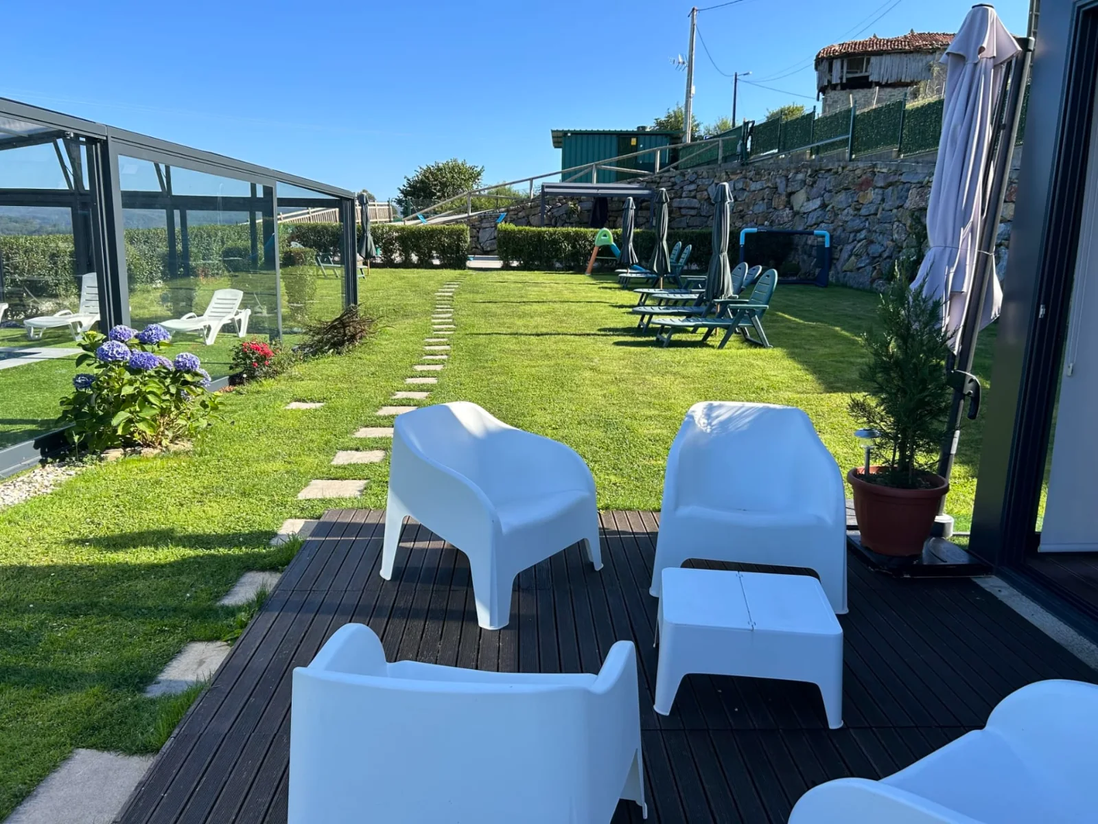 Jardín del complejo con sillones blancos y vistas al valle