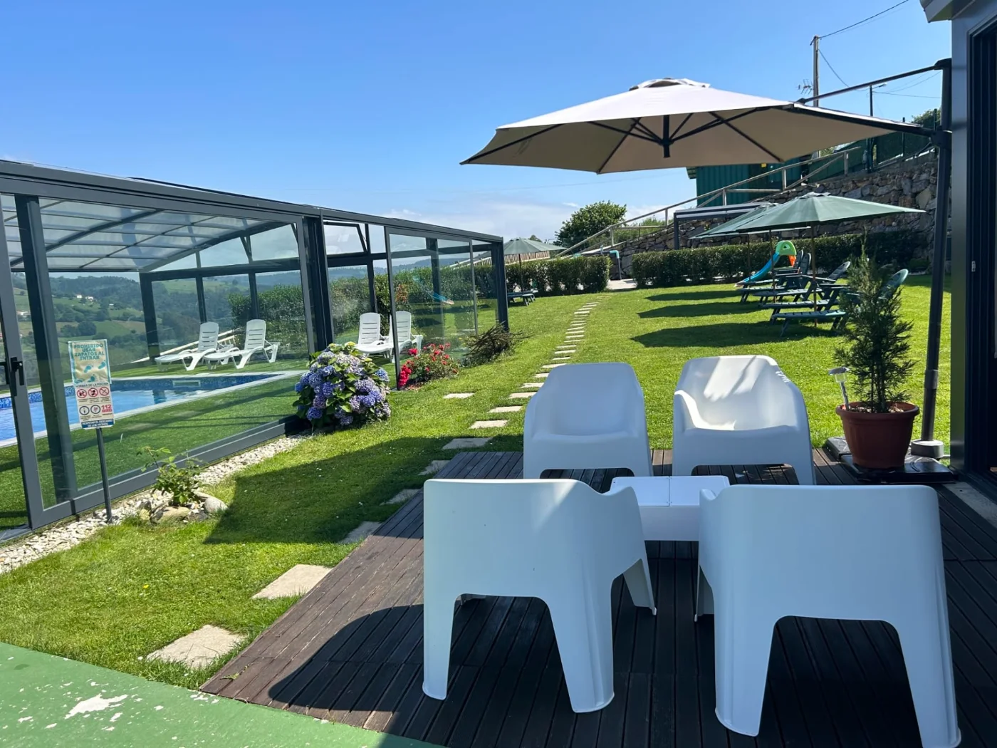 Terraza junto a la piscina con sombrilla